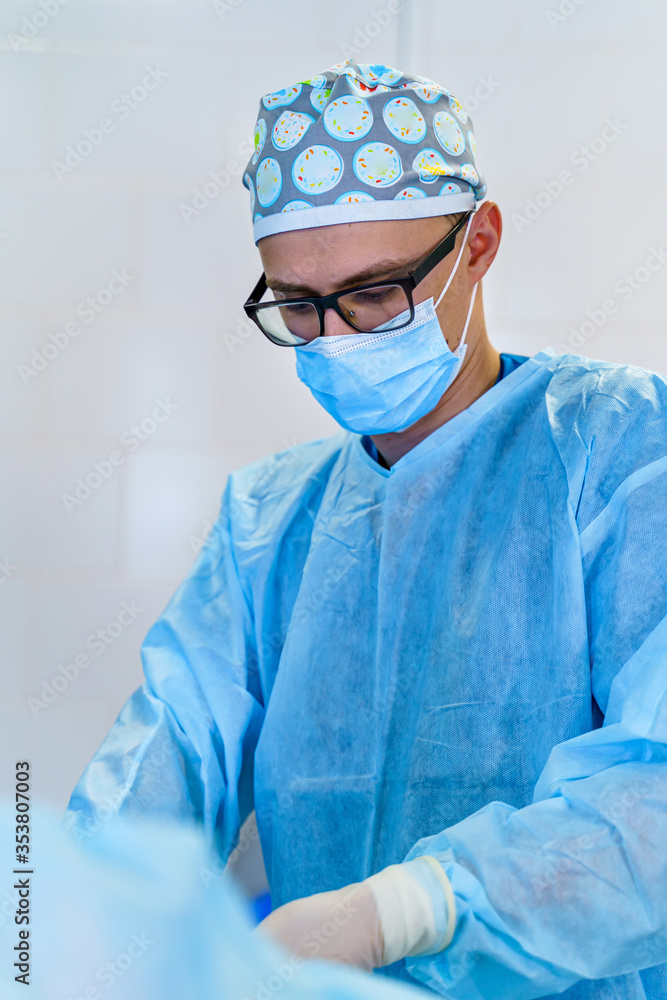 Doctor in operating room with surgery equipment. Doctor providing operation. Modern medical backgrou