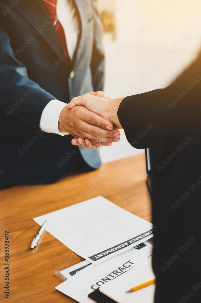 商务人士在达成协议并签署合同后握手。