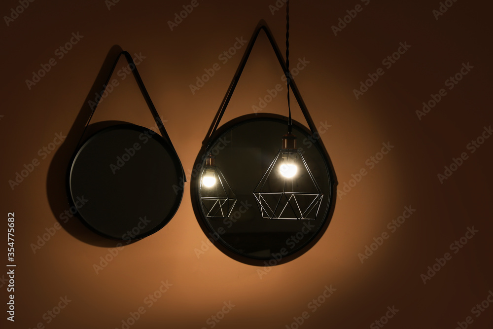 Mirrors with glowing lamp in dark room
