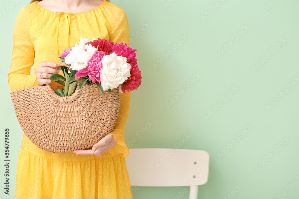 年轻女子，彩色背景的袋子里有美丽的牡丹花