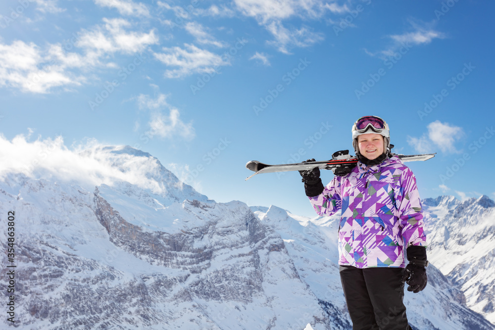 戴着面具，戴着头盔，面带微笑，坚持滑雪的青少年滑雪女孩画像