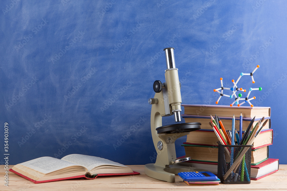 教育和科学概念——礼堂桌子上的书籍、分子模型和显微镜，
