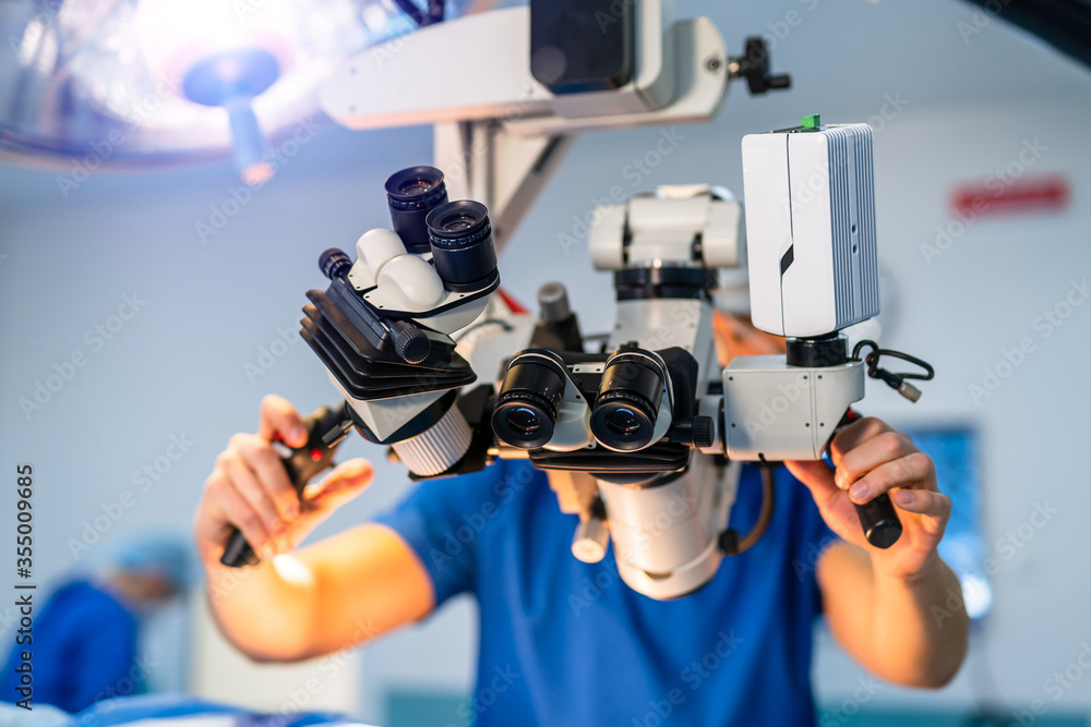 手术室手术用现代显微镜。一群外科医生在手术期间使用手术显微镜