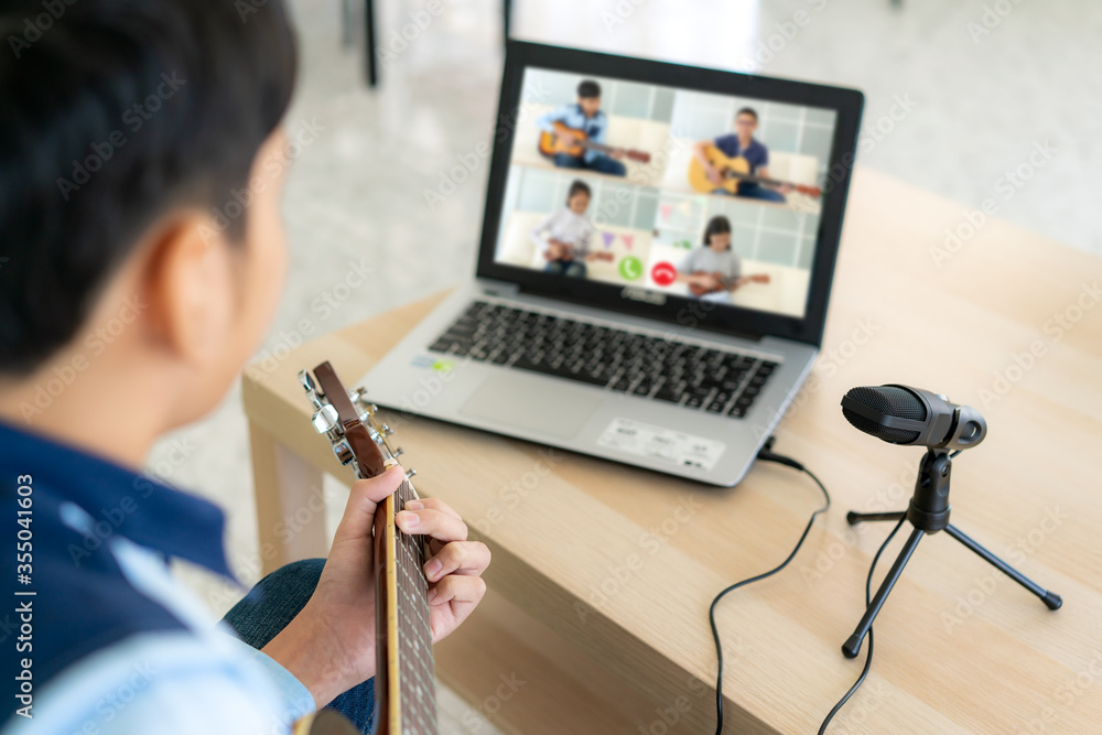 亚洲男孩弹原声吉他虚拟欢乐时光会议，与fri一起在线播放音乐