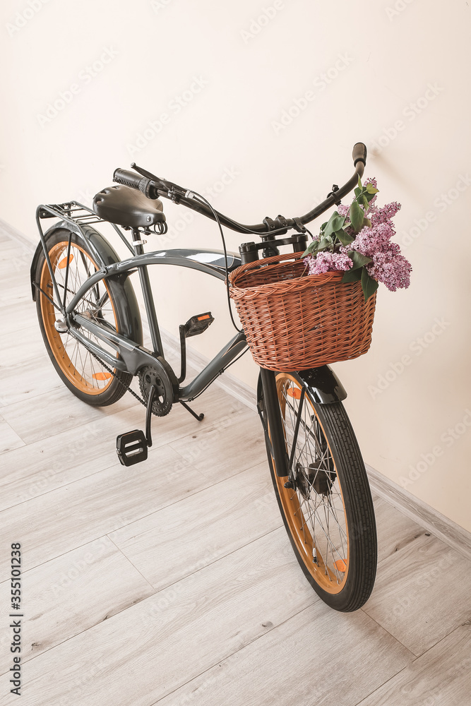 现代自行车和柳条篮，灯墙附近有花