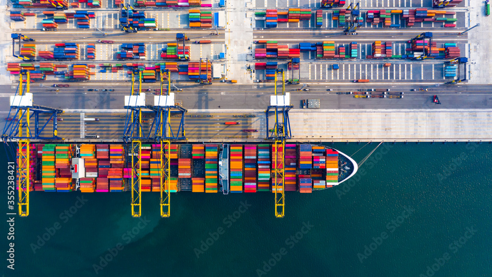 码头海港集装箱船鸟瞰图，配有拖船，全球商务货运船