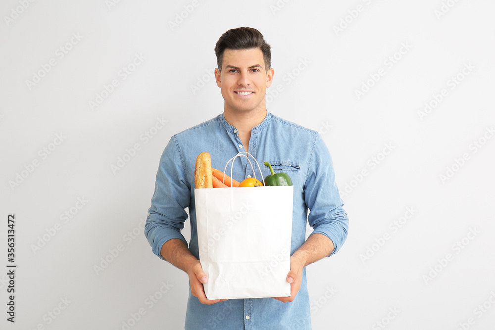 年轻人拿着浅背景食物的袋子