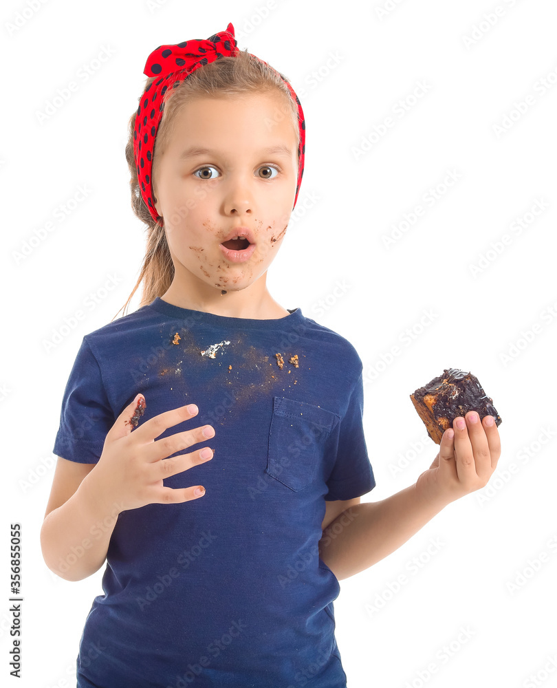 Little girl in dirty clothes eating chocolate on white background