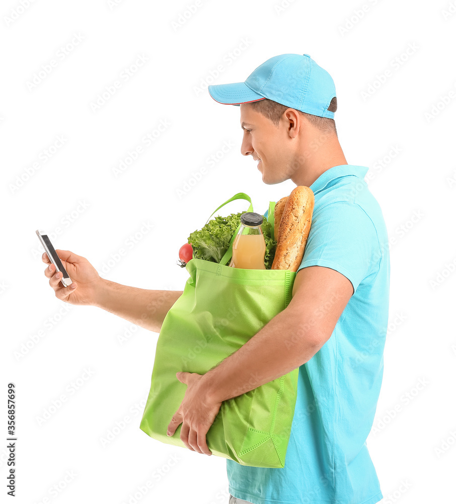 Delivery man with food in bag and mobile phone on white background