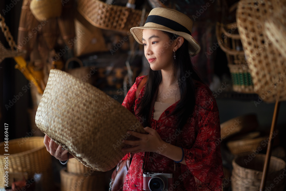 Asian girl, travel and shopping in traditional basketry shop