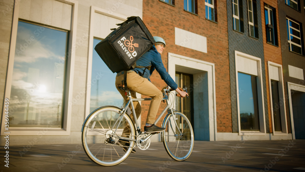 快乐送餐快递员穿着保暖背包骑自行车在路上送餐
