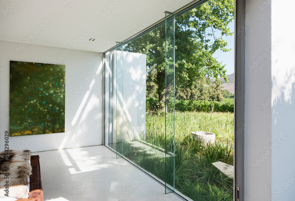 玻璃墙俯瞰草地的现代房子