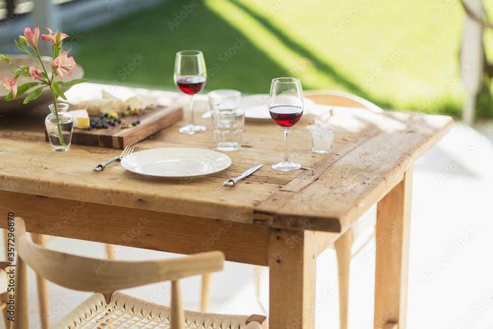 Wine and appetizer on wooden dining table on patio