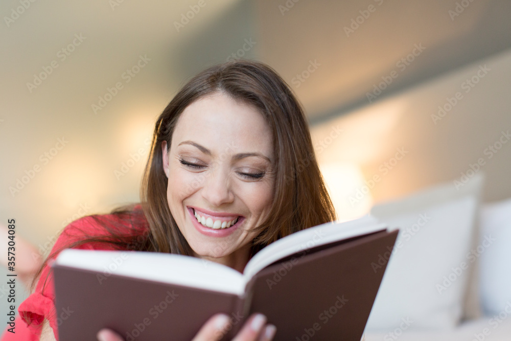 微笑的女人在卧室看书