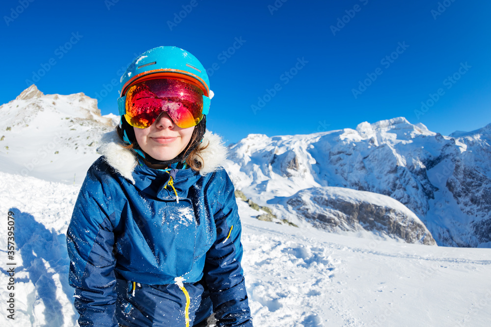 快乐少女在雪地里戴着可爱的冬季滑雪服眼镜和头盔微笑的近照