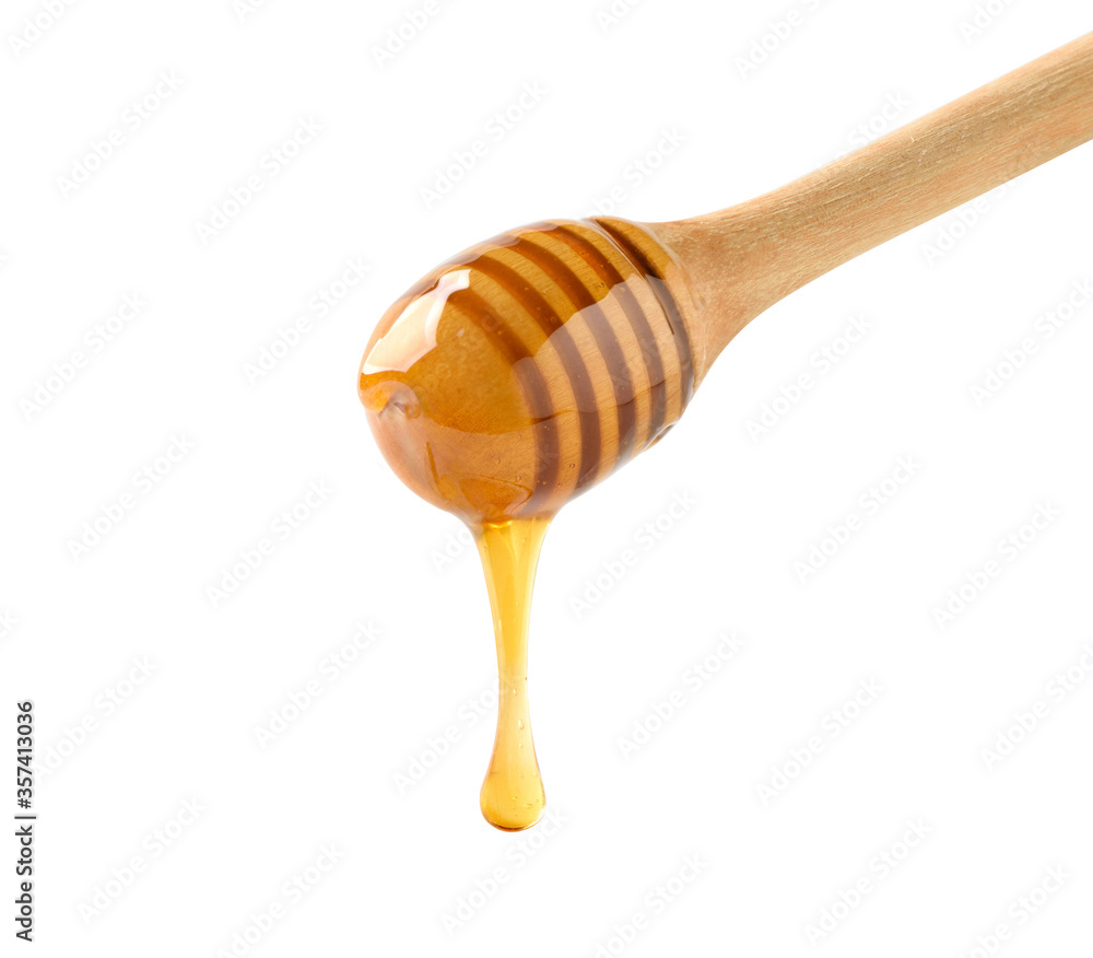蜂蜜从白色背景上的蜂蜜勺中滴落
