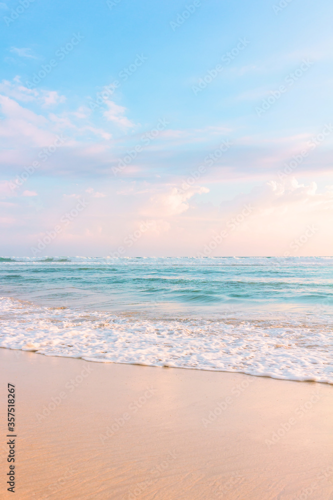 沙滩，蓝色多云的天空和柔和的海浪，伴随着温暖的日落。