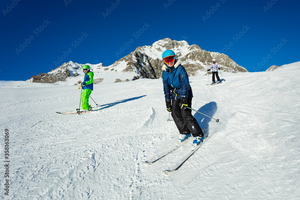 Group of kids and teenagers ski on the hill with friends portrait, sunny day on Alpine mountain reso