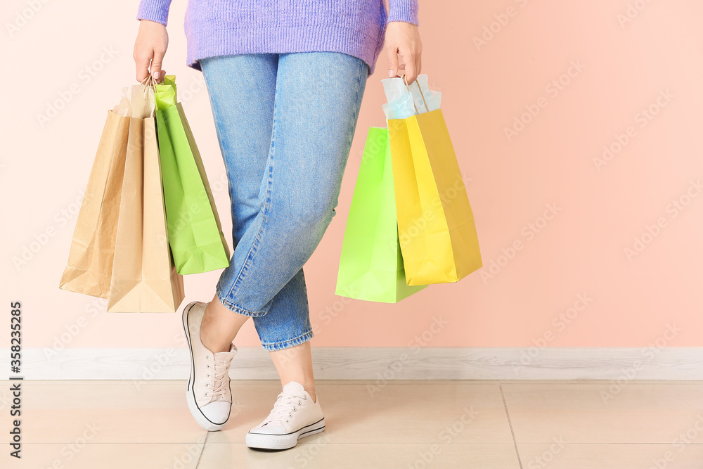 Woman with shopping bags near color wall