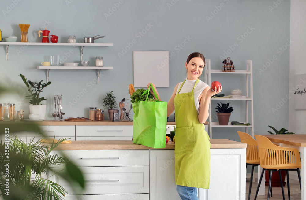 妇女在厨房里打开市场上的新鲜产品