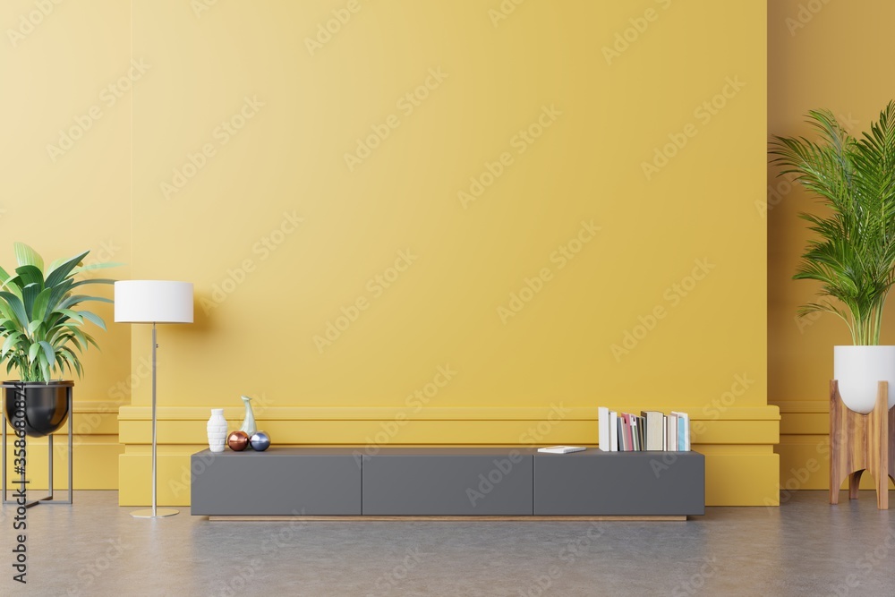 在现代客厅放置电视或物品的橱柜，黄色墙上有灯、桌子、花草