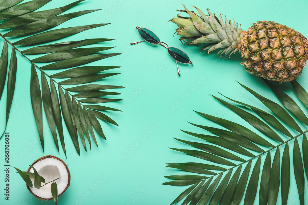 以热带水果和棕榈叶为背景的时尚太阳镜