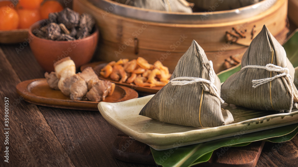 粽子——红砖墙木桌上的蒸笼中的中国粽子食品，靠窗