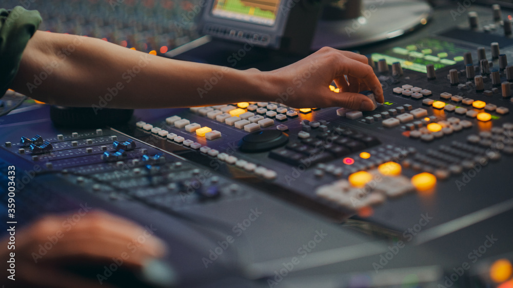 音频工程师、音乐家、艺术家在录音室工作，控制台混音器。手触摸