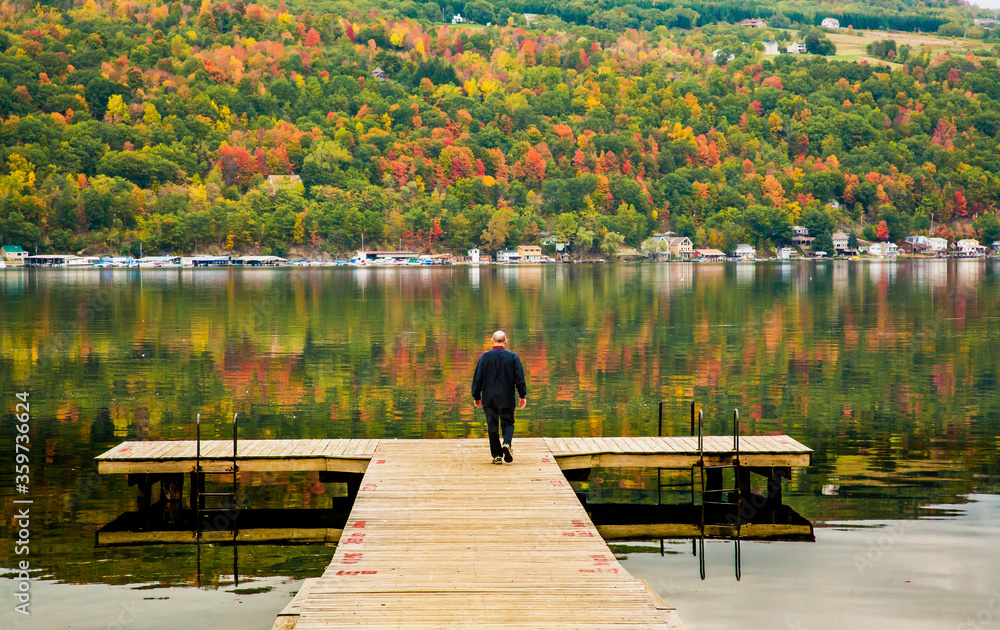 一名男子在纽约州上城区芬格湖区塞内卡湖的游泳/钓鱼码头上行走