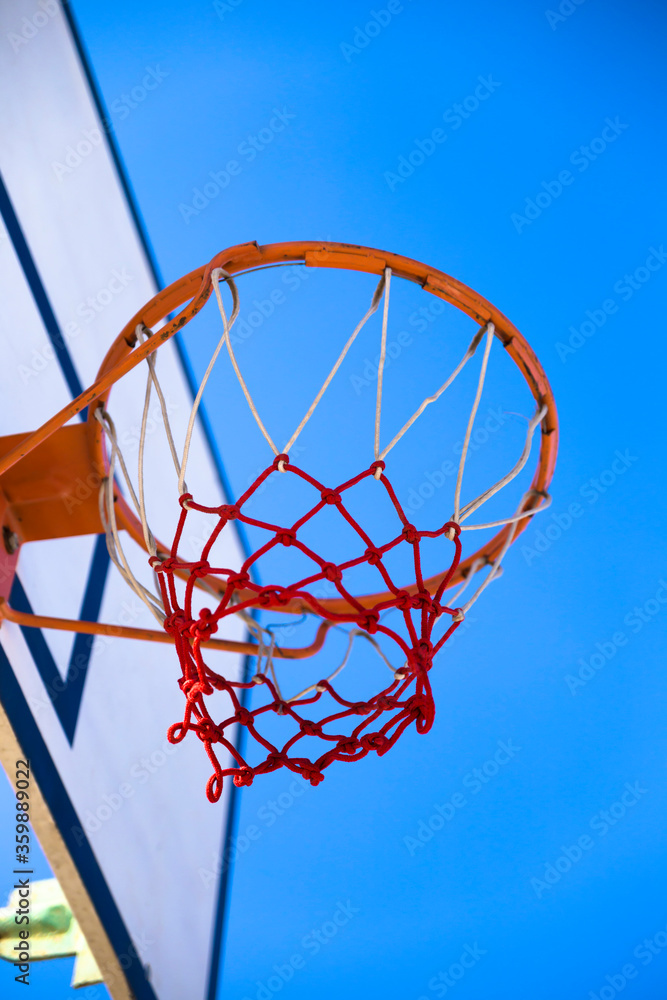 蓝色背景的篮球，棒球圈篮球篮筐和篮网的特写