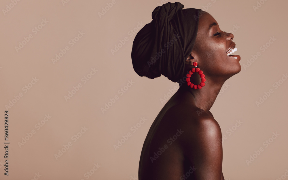 米色背景下微笑的时尚非洲女人