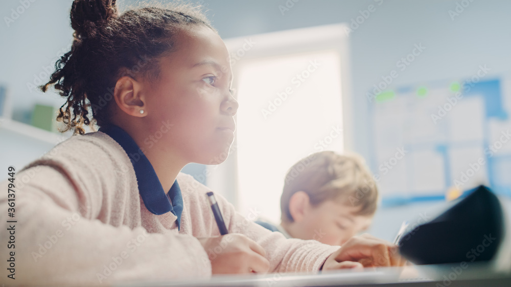 在小学课堂上，黑人女孩在练习本上写作，参加考试。初中课堂