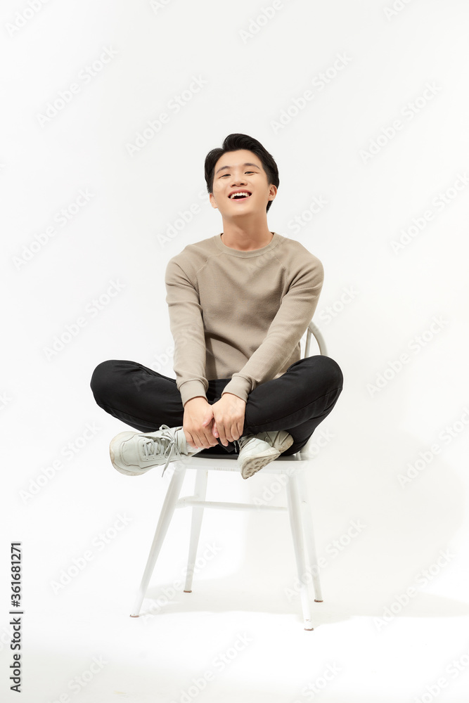 一幅快乐的亚洲男人坐在白底椅子上的画像