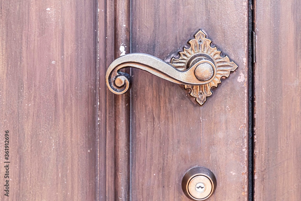 特写古董经典黄铜开门器和棕色木门