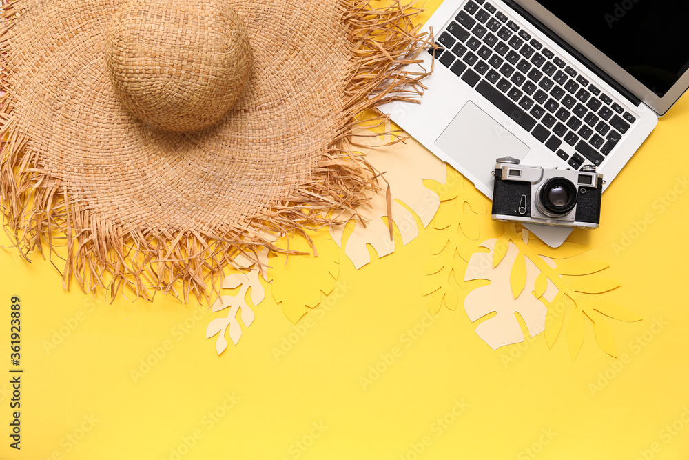 带沙滩帽、相机和笔记本电脑的彩色背景构图