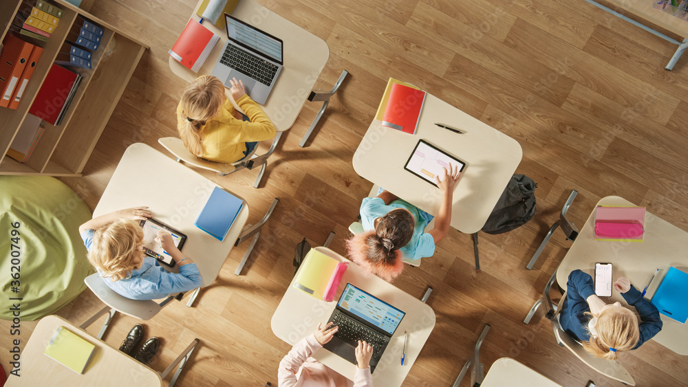 Top View Shot in Elementary School Computer Science Classroom: Children Sitting at their School Desk