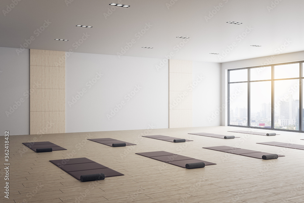 瑜伽教室的极简主义室内，配有垫子和城市景观。