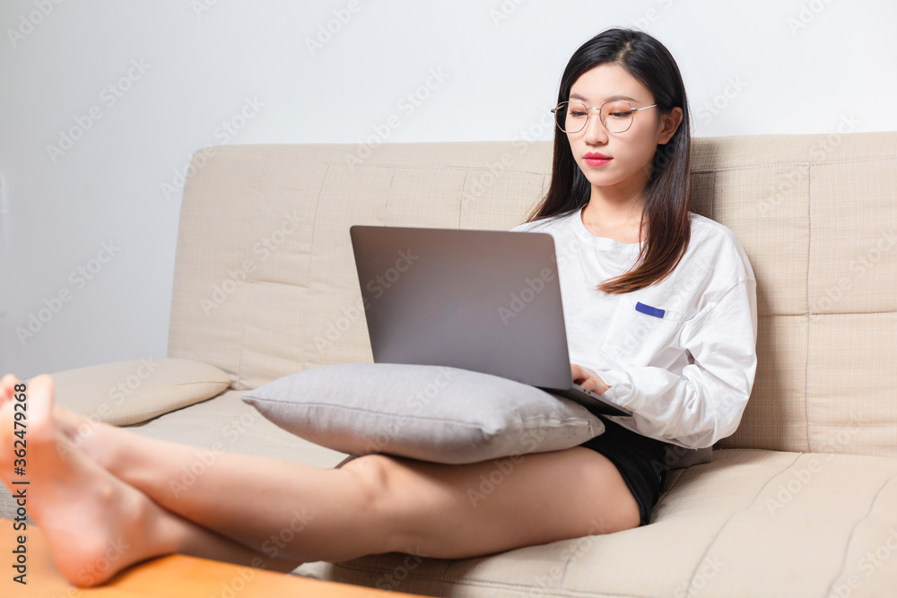 躺在沙发上的美女正在用电脑视频聊天
