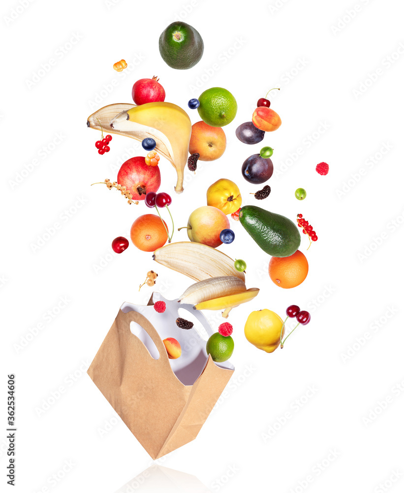 白色背景下，各种水果和浆果从纸袋里飞出来