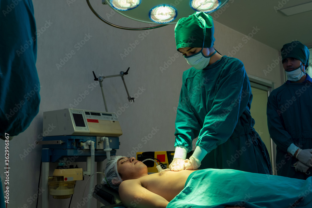 外科医生正在医院手术室为危重患者使用除颤器。