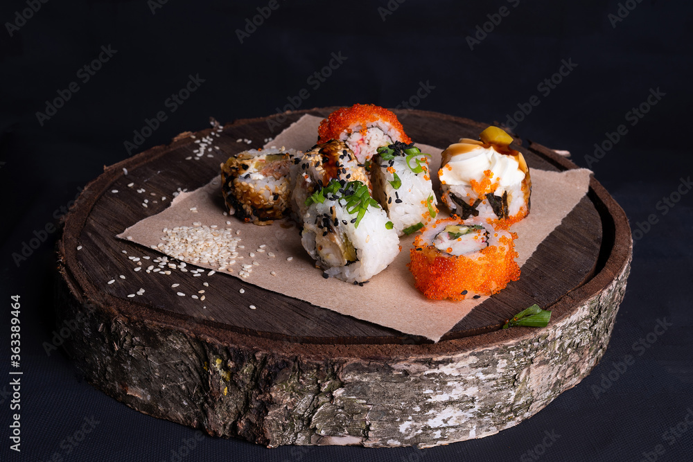 日本edp寿司卷放在木托盘上，寿司卷配金枪鱼、蔬菜和日本寿司酱。