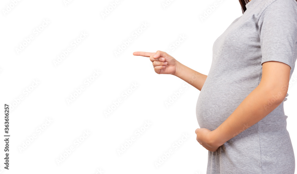 Pregnant mother pointing finger to copy space and touching her abdomen. Pregnant woman care and love