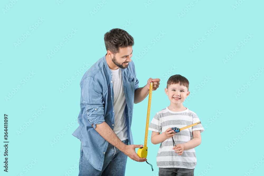 父亲和儿子带着彩色背景的卷尺