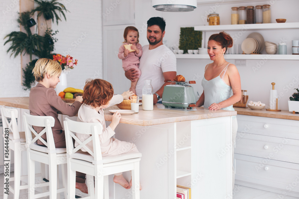 幸福的家庭，三个孩子早上在家吃早餐，现代化的厨房内部