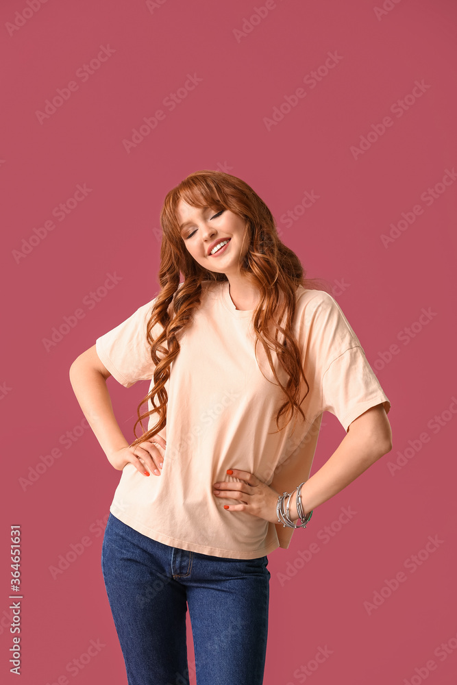 美丽的年轻红发女人在彩色背景下