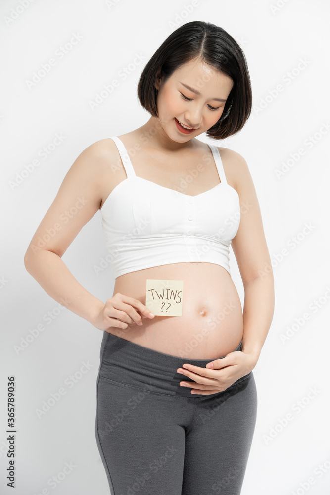 孕妇腹部特写，白色背景上有纸条