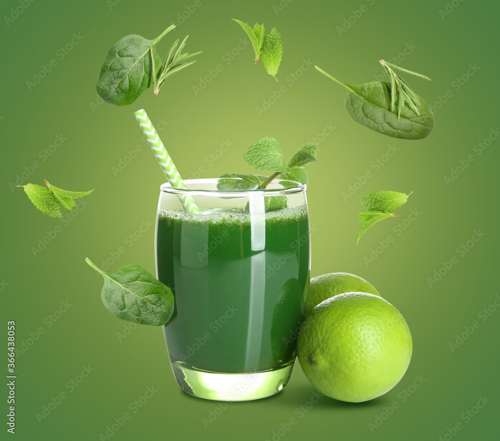 Glass of tasty juice and flying ingredients on color background
