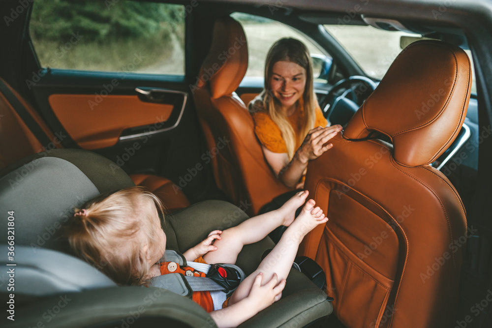 家人坐在车里的孩子坐在安全座椅上，母亲开车旅行度假旅行的生活方式