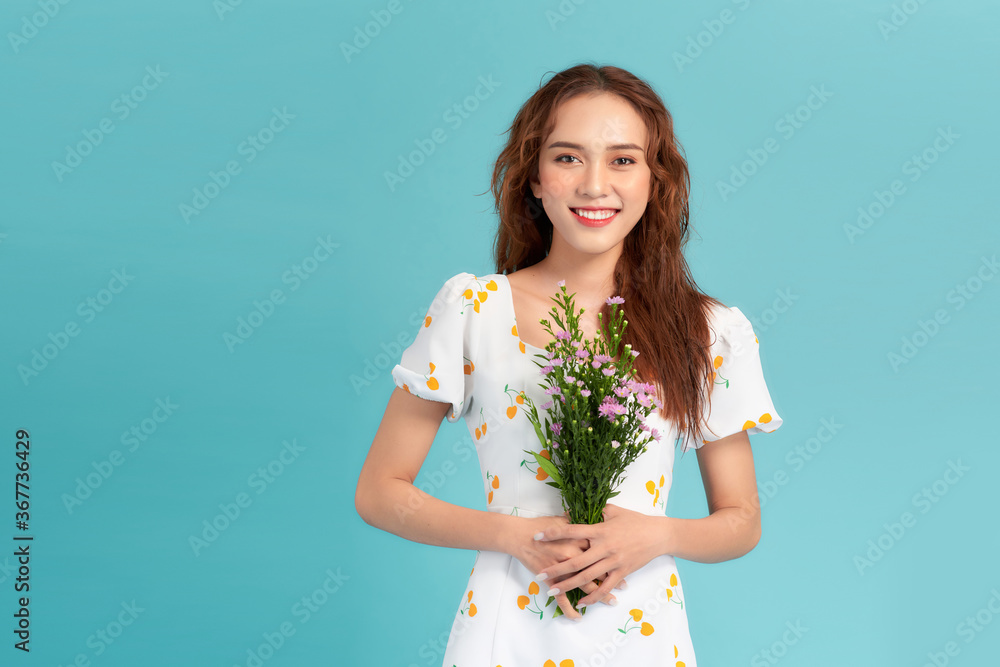 快乐的年轻女孩手里拿着一束鲜花。