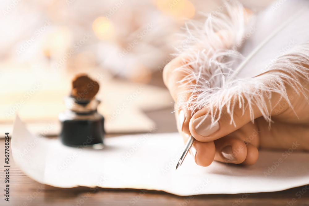 Woman writing letter with feather pen, closeup